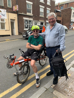 A man on a recumbent bike and a man standing next to him