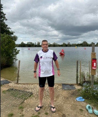 A man wearing a CLL Support tshirt next to a lake
