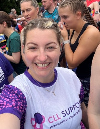 A woman wearing a CLL Support t-shirt with other runners behind her